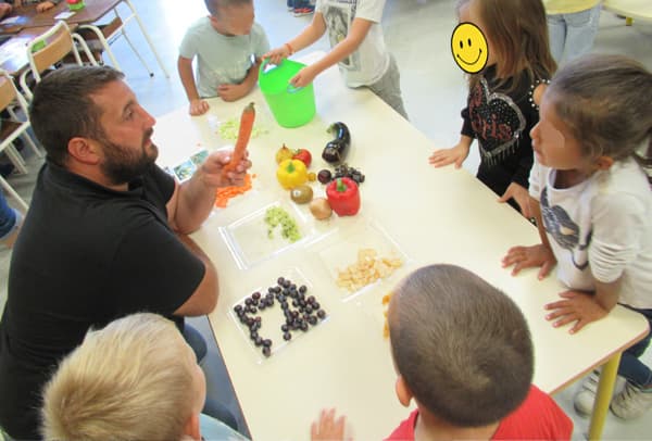 Enfant nommant les fruits et légumes avec un papa à l'atelier 'Fruits et légumes'