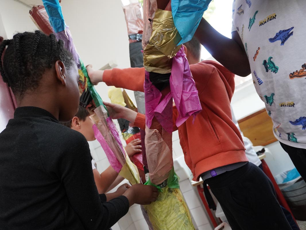 Élèves créant un arbre pour le spectacle sur l'écologie avec des objets recyclés