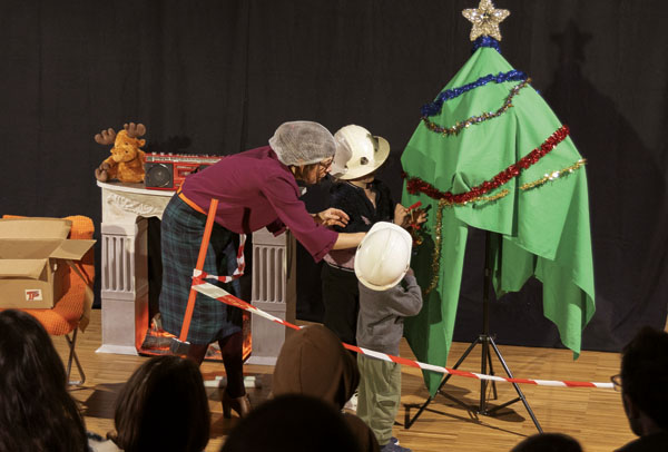 Les enfants décorent le sapin sur scène dans le spectacle Un Noël en chantier